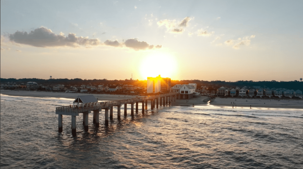 Hotel drone video content capturing sunset over Surfside Beach pier and Surfside Oceanfront Hotel in South Carolina
